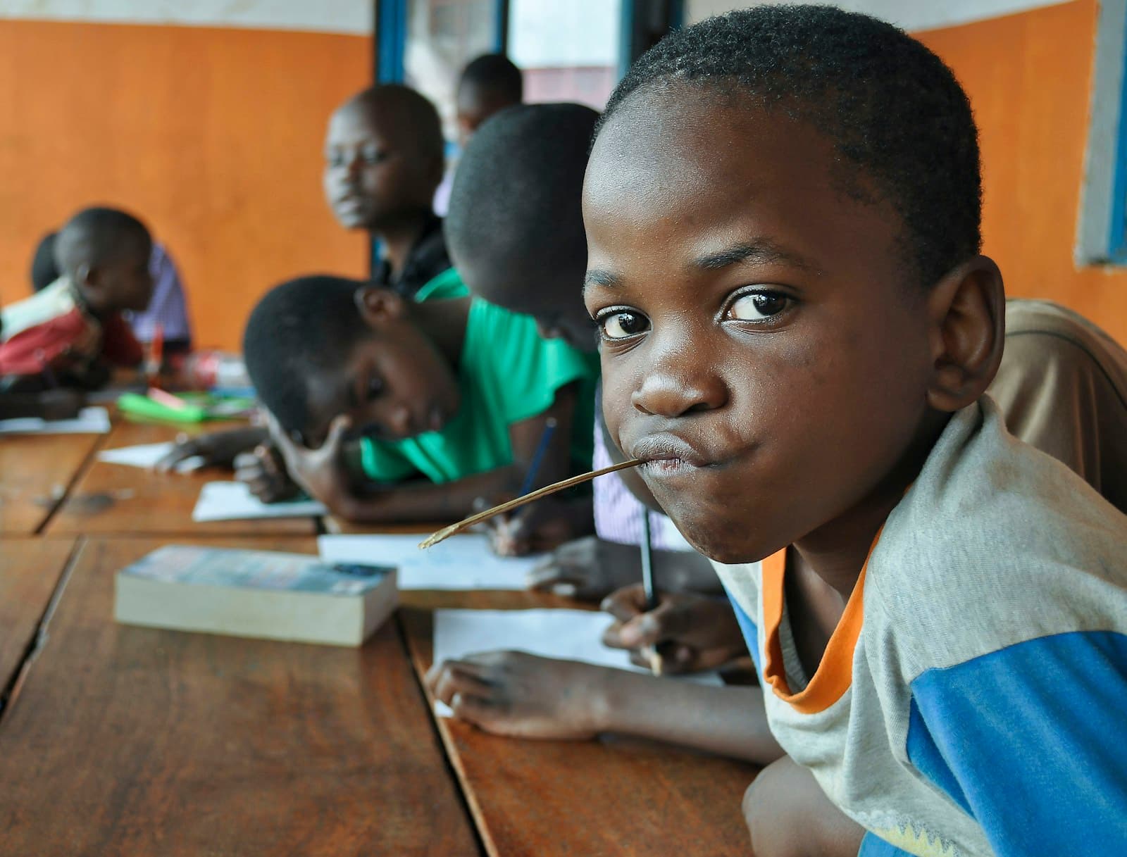 A group of young students sitting at a table in Wakiso, Uganda — Photo by Felicia Montenegro on Unsplash