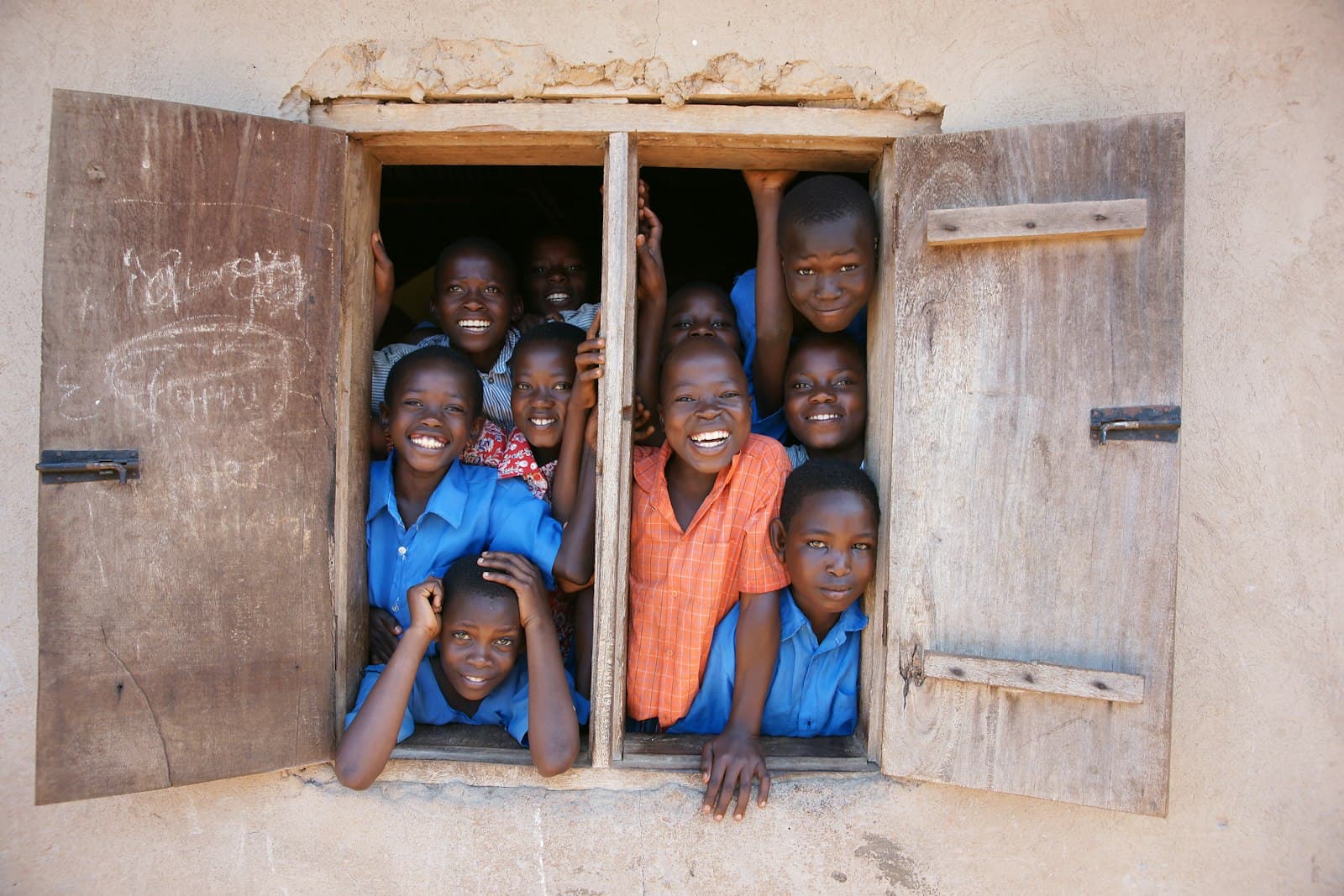 A group of young children standing in a window — Photo by bill wegener on Unsplash